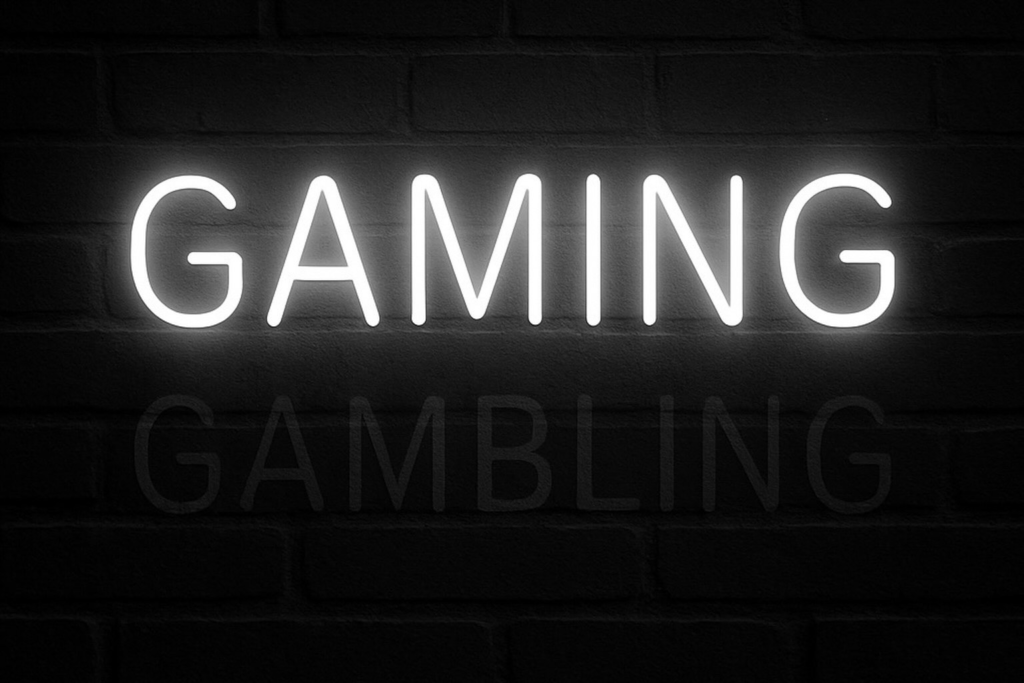 Neon sign displaying the word “GAMING” with a faint, harder-to-see “GAMBLING” underneath, symbolizing how language alters perception